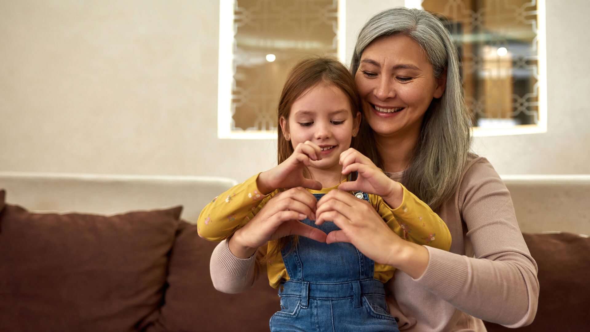 Little girl in heart shape sit on nanny's lap